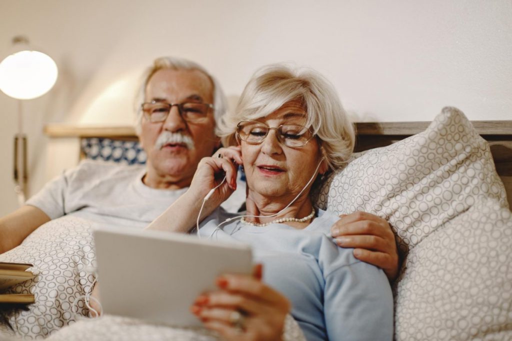 Vieux couple heureux suivant une vidéoconférence sur leur telephone