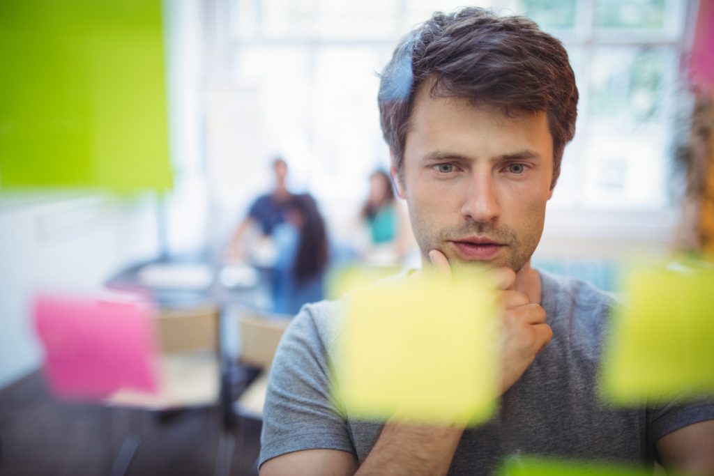 Jeune homme concentré sur des cartes multicolores