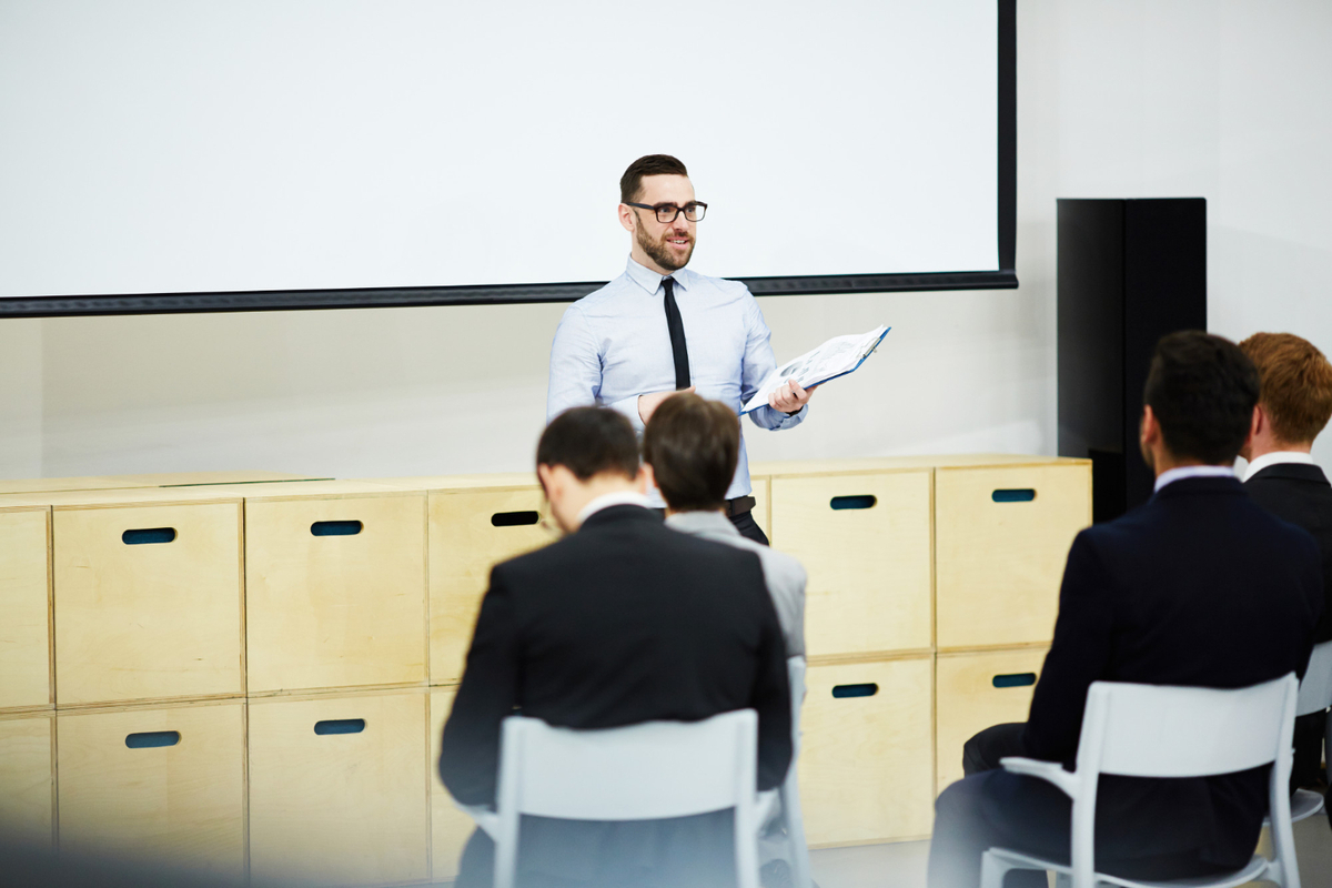 Jeune professeur lit devant des apprenants